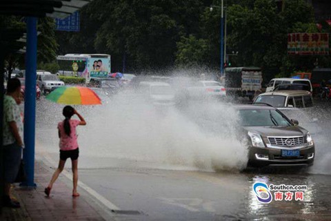 7月21日，廣州下起雷暴雨，暴雨造成不少低洼地區(qū)水淹，圖為廣州大道北一低洼處，一輛行駛而過的車輛濺起了近三米高的水花，一旁的行人紛紛躲避。（南方日?qǐng)?bào)記者 郭智軍 攝）